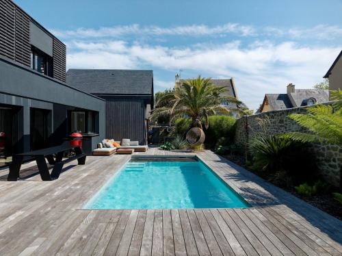 - une piscine dans une cour avec une terrasse en bois dans l'établissement Villa Élisa, à Saint-Malo