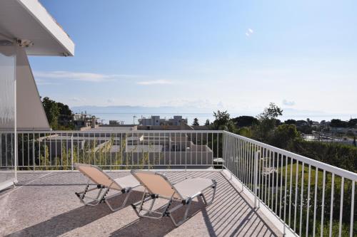 two chairs on the balcony of a house at Stunning Seaview Apartment in Mati, Nea Makri in Nea Makri