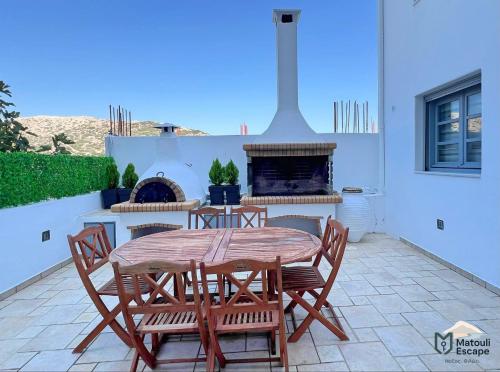 a patio with a table and chairs and a fireplace at Matouli Escape in Philotium