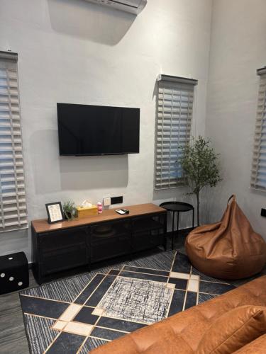 a living room with a flat screen tv on a wall at Industrial Loft Tinyhouse Homestay - 2 Queen Bed, Free Netflix, Prime & Wi-Fi Near Bukit Mertajam in Kubang Semang
