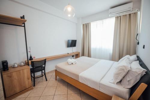 a bedroom with a bed and a desk and a chair at Thirsty Dog Urban Port Studios in Igoumenitsa