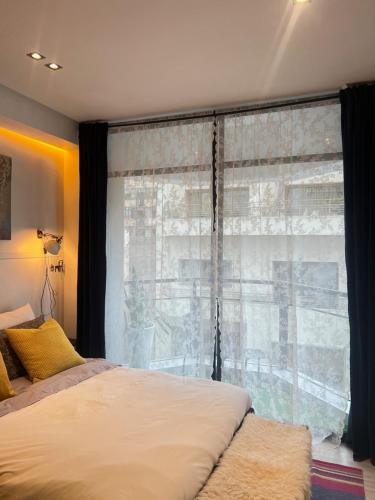 a bedroom with a bed and a large window at Stay In GAUTHIER studio s in Casablanca