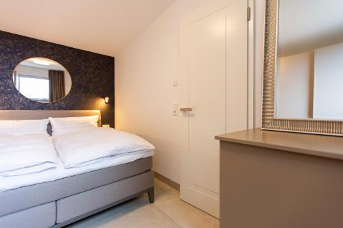 a bedroom with a bed and a mirror at Haus Anna Atelier in Ahrenshoop