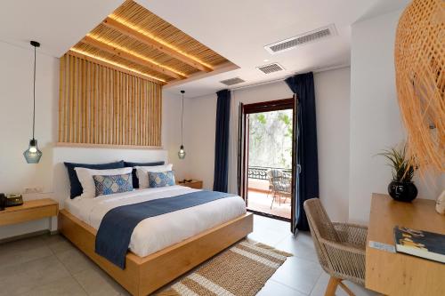 a bedroom with a bed and a balcony at Aktaion Beach Boutique Hotel & Spa in Skala