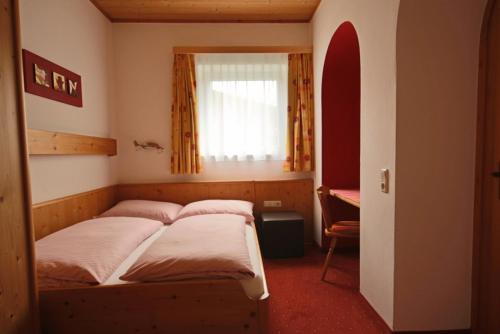 1 dormitorio con 2 camas y ventana en MIMO Appartements en Saalbach Hinterglemm