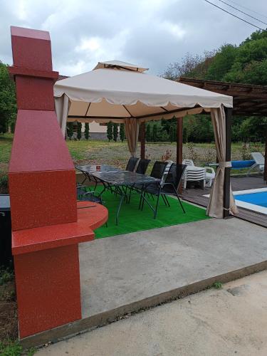 a patio with a table and an umbrella at Milica 2 Mezdrejska 87 A in Crni Vrh