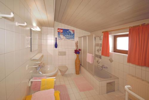 ein Badezimmer mit einem Waschbecken, einem WC und einer Badewanne in der Unterkunft MIMO Appartements in Saalbach-Hinterglemm