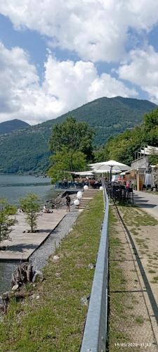 a walkway next to a body of water with tables and chairs at Casa Caterina - Riva di Solto - Iseo Lake in Riva di Solto