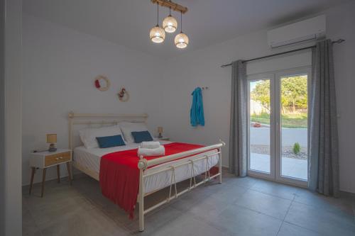 a bedroom with a bed and a sliding glass door at Leros Houses Sea View 2 in Lépidha