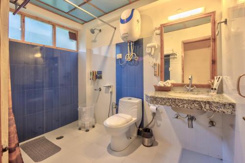 a bathroom with a toilet and a sink and a mirror at V V Aero a wooden exotic stay Near Old Manali in Manāli