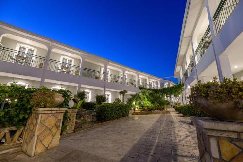 a courtyard of a building with potted plants at Sofia's Hotel in Kalamaki