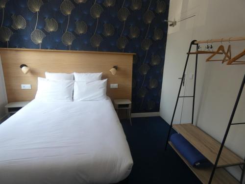 a bedroom with a large white bed and a ladder at Hôtel de France in Pont-lʼÉvêque