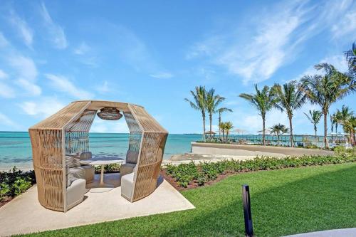 a gazebo with a table and chairs in the grass at Beachfront 3 bedroom Luxury Residence in Nassau