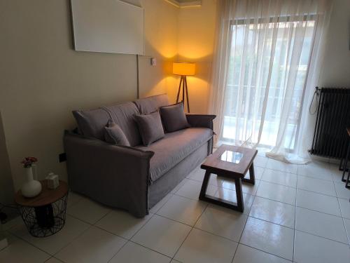 a living room with a couch and a table at Samothraki Echo Apartment in Alexandroupoli