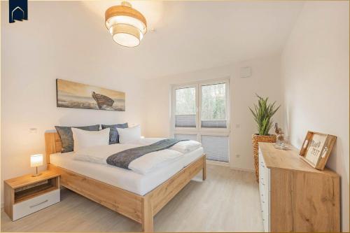 a bedroom with a large bed and a window at FeWo Meerzeit Bernsteinquartier in Loddin