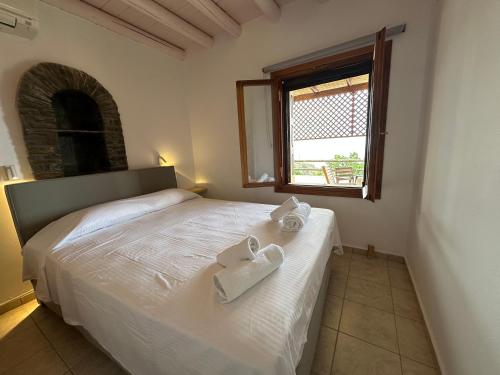 a bedroom with a white bed with towels on it at Andros Escape Condos in Andros