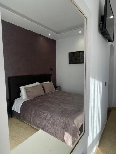 a bedroom with a bed and a mirror at Hotel Riviera in Durrës