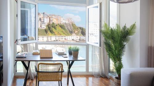 a table and chairs in a room with a large window at AG Piso Porto de Mar Malpica, a 250m de la playa in Malpica