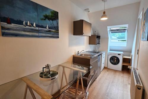 - une cuisine avec une table en verre et un évier dans l'établissement New studio 26 m with Wifi in Vannes, à Vannes