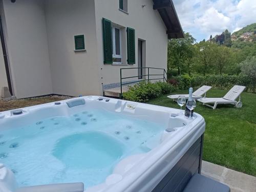 a hot tub in the backyard of a house at Ema Home - nature and Lake Como - Argegno in Dizzasco