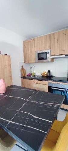 une cuisine avec un comptoir noir dans l'établissement Vivre le Bassin !, à La Teste-de-Buch