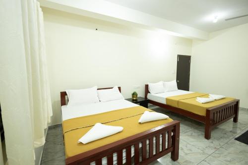 a bedroom with two beds and a table at Golden Crest Residences in Napoklu