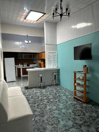 a living room with a couch and a kitchen at Casa Buen Agüero in San Antonio