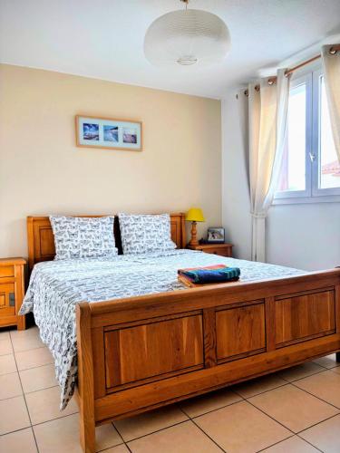 a bedroom with a large bed with a wooden frame at Jolie Chambre chaleureuse in Marseille