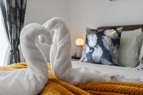 two swans made out of towels on a bed at City Centre Studio Apartments - Ashton Apartment - Short Stays UK Ltd in Exeter