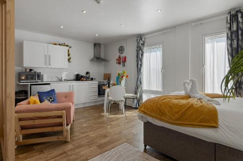 a bedroom with a large bed and a kitchen at City Centre Studio Apartments - Ashton Apartment - Short Stays UK Ltd in Exeter