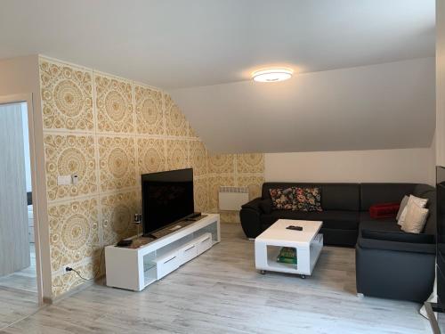 a living room with a couch and a flat screen tv at Apartmán Paseky in Terchová
