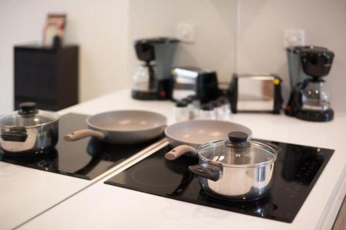 a stove top with two pots and pans on it at Sky Suites KLCC By Star Apartment in Kuala Lumpur