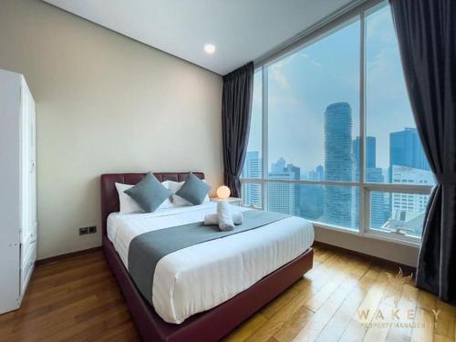 a bedroom with a large bed with a large window at Sky Suites KLCC By Star Apartment in Kuala Lumpur