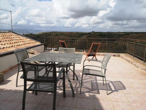 eine Terrasse mit Tisch und Stühlen auf einem Balkon in der Unterkunft Casa vacanze San Martino in Irsina