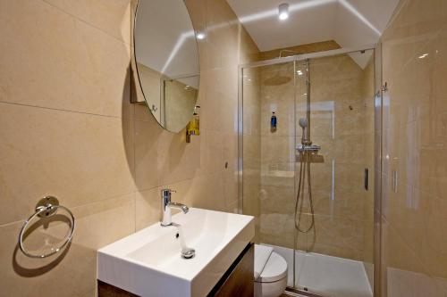 a bathroom with a sink and a shower at Imperial Middlesex Street Apartments in London