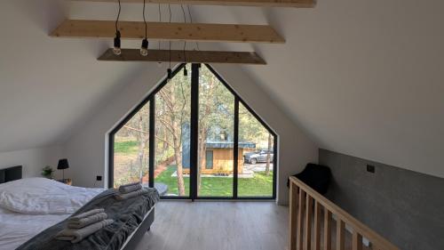 una camera da letto con un letto e una grande finestra di Sosnowy Raj Borsk a Borsk