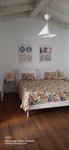 a bedroom with a bed with a comforter at Civico 381 - private parking in Quartu SantʼElena