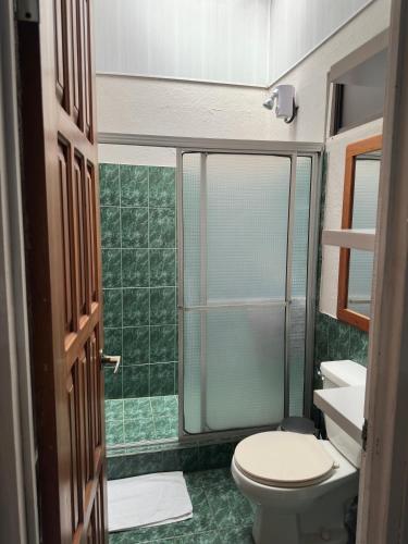 a bathroom with a toilet and a glass shower at Casa Buen Agüero in San Antonio