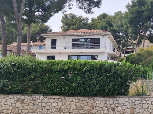 a white house behind a stone wall at Appartement spacieux T3 neuf in Cassis