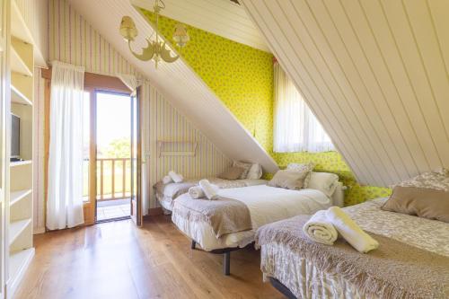 a bedroom with two beds in a room with yellow walls at villa dario in Argoños