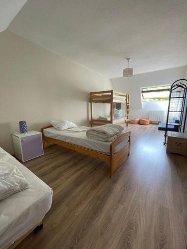 une chambre avec deux lits et un parquet dans l'établissement Les Marmottes de Guchen - 12 pers - 5 min de Saint-Lary-Soulan, à Guchen