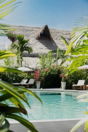 a swimming pool in front of a resort with chairs and a building at Anzalik Hotel Boutique in Anzá