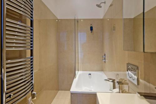 a bathroom with a tub and a sink and a shower at Imperial liverpool street apartments in London