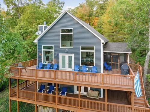 a house with a large deck with blue chairs at Rough River Multi Family Charmer in McDaniels
