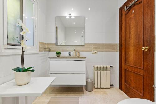a white bathroom with a sink and a mirror at Villa Roco Marbella private pool and sea view in Marbella