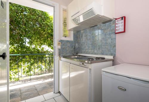 a small kitchen with a stove and a window at Sofia's Hotel in Kalamaki