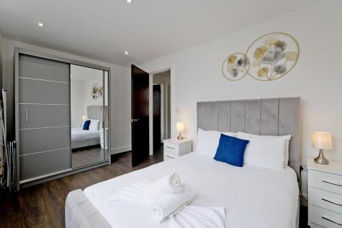 a bedroom with a large white bed and a mirror at Imperial liverpool street apartments in London