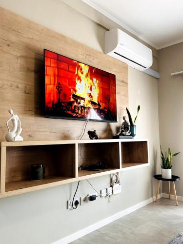 a television on a wall with a fireplace at PrimVilla Apartment in Gaborone
