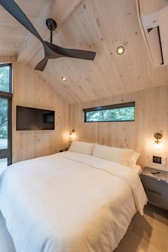 a bedroom with a large bed with a ceiling fan at Black Prong Resort in Bronson