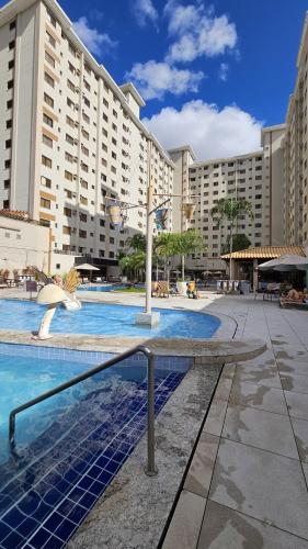 a large building with a swimming pool in front of it at Thermas Boulevard Suíte Hotel - Weigly in Caldas Novas
